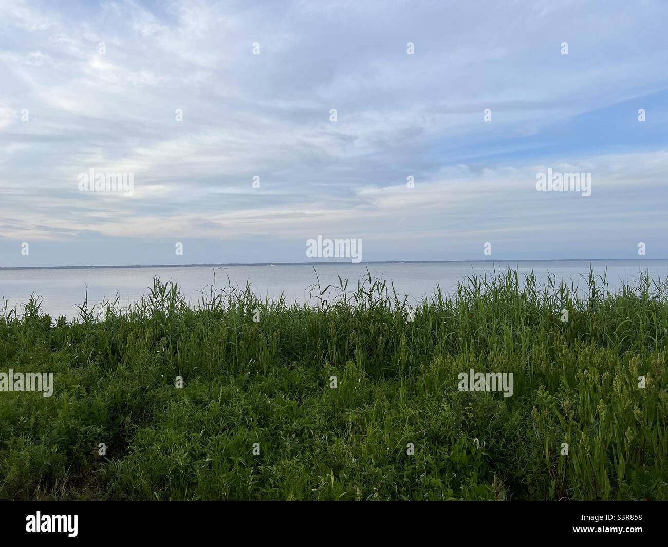 Nuvole al tramonto morbide sull'acqua della baia Foto Stock