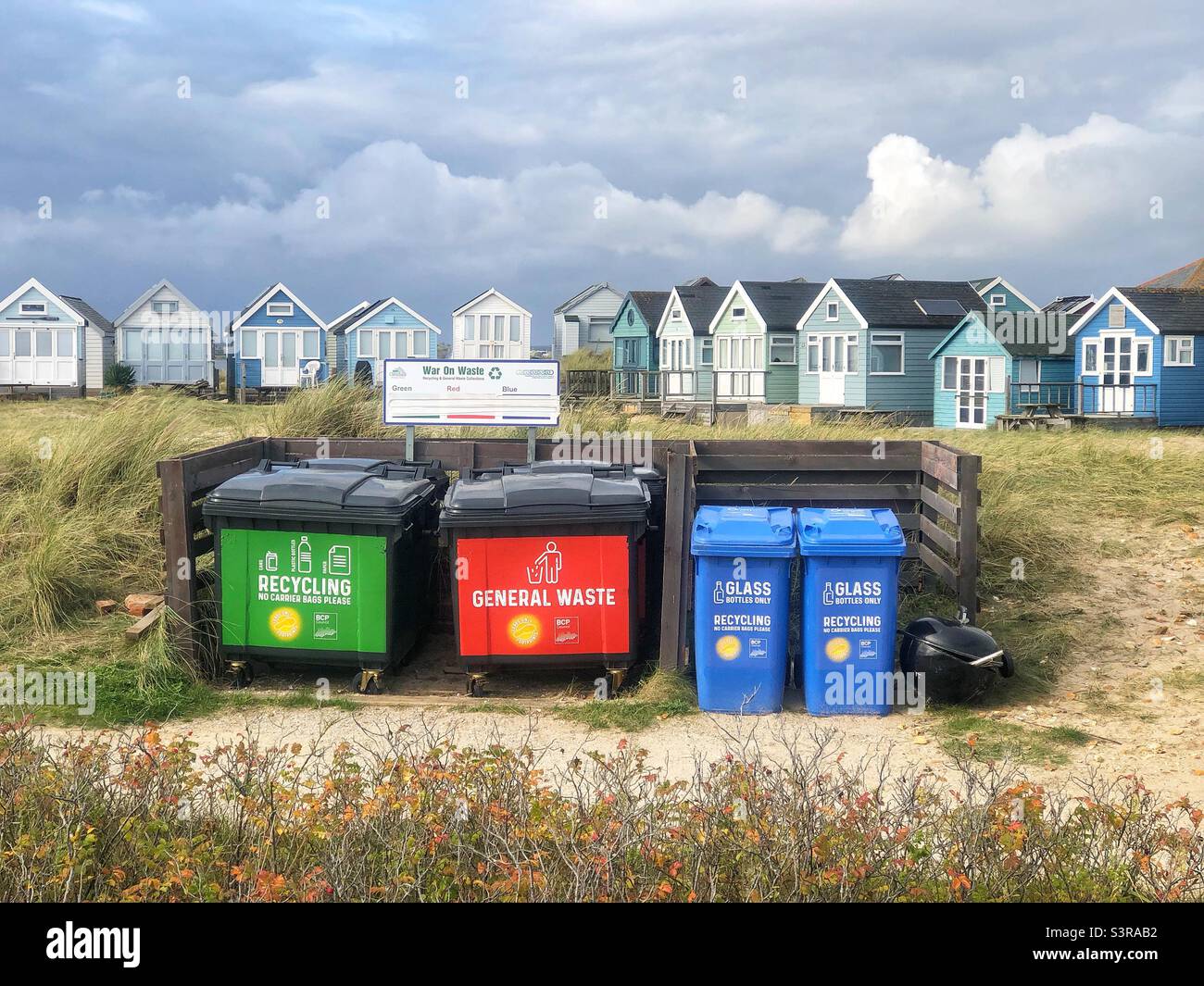 Riciclare i bidoni dei rifiuti di fronte alle capanne della spiaggia a Mudeford Sandbanks, Dorset, Regno Unito - Immagine stock catturata con smartphone
