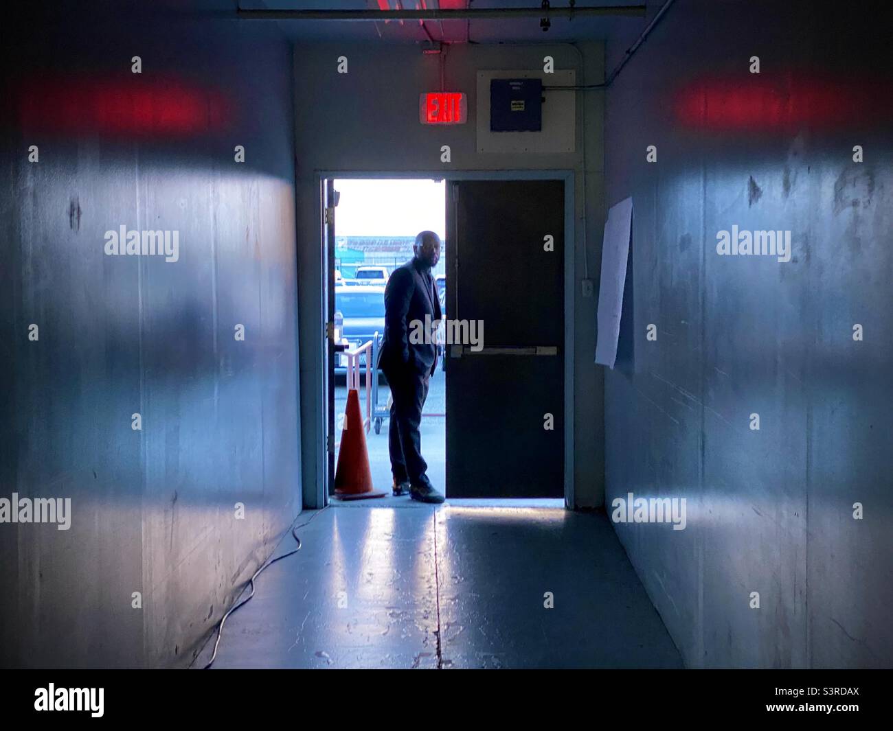 LOS ANGELES, CA, SETTEMBRE 2021: La persona di sicurezza si è vista a porta all'Other Art Fair, Barker Hangar, l'aeroporto municipale di Santa Monica, con riflessi sulle pareti su entrambi i lati - Immagine stock catturata con smartphone