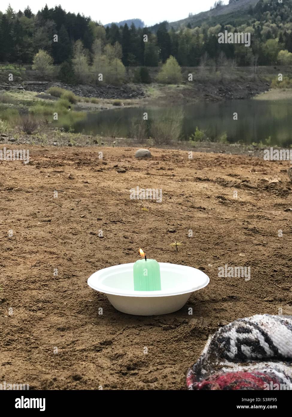 Candela posta sulla spiaggia di argilla per una celebrazione Beltane. Foto Stock