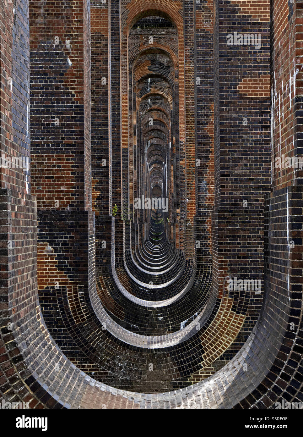 Guardando attraverso gli archi del viadotto ferroviario della Valle dell'Ouse, Balcombe, West Sussex, Inghilterra. Foto Stock