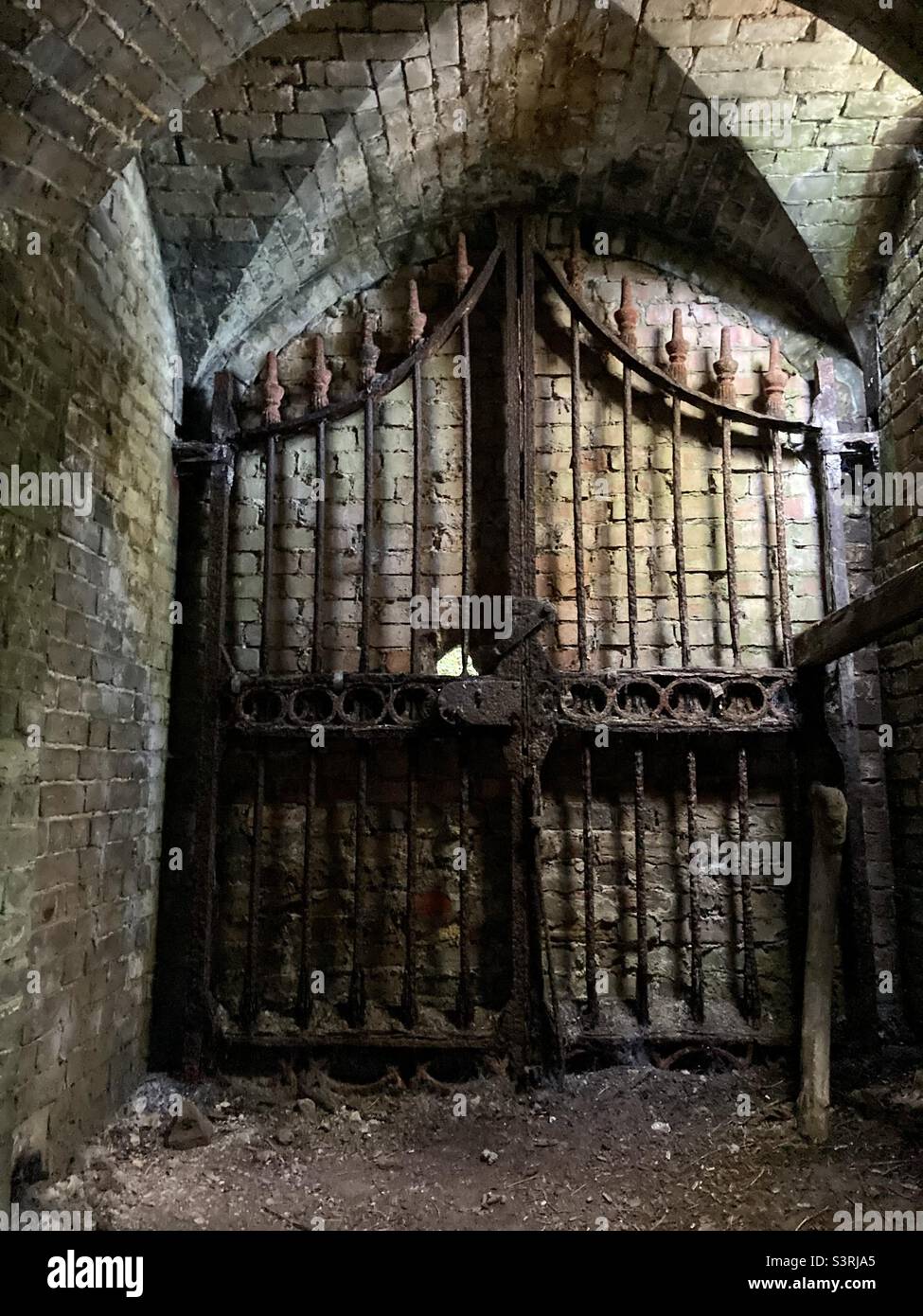 Porta arrugginita in un tunnel in muretto risalente al 1800 - Immagine stock catturata con smartphone