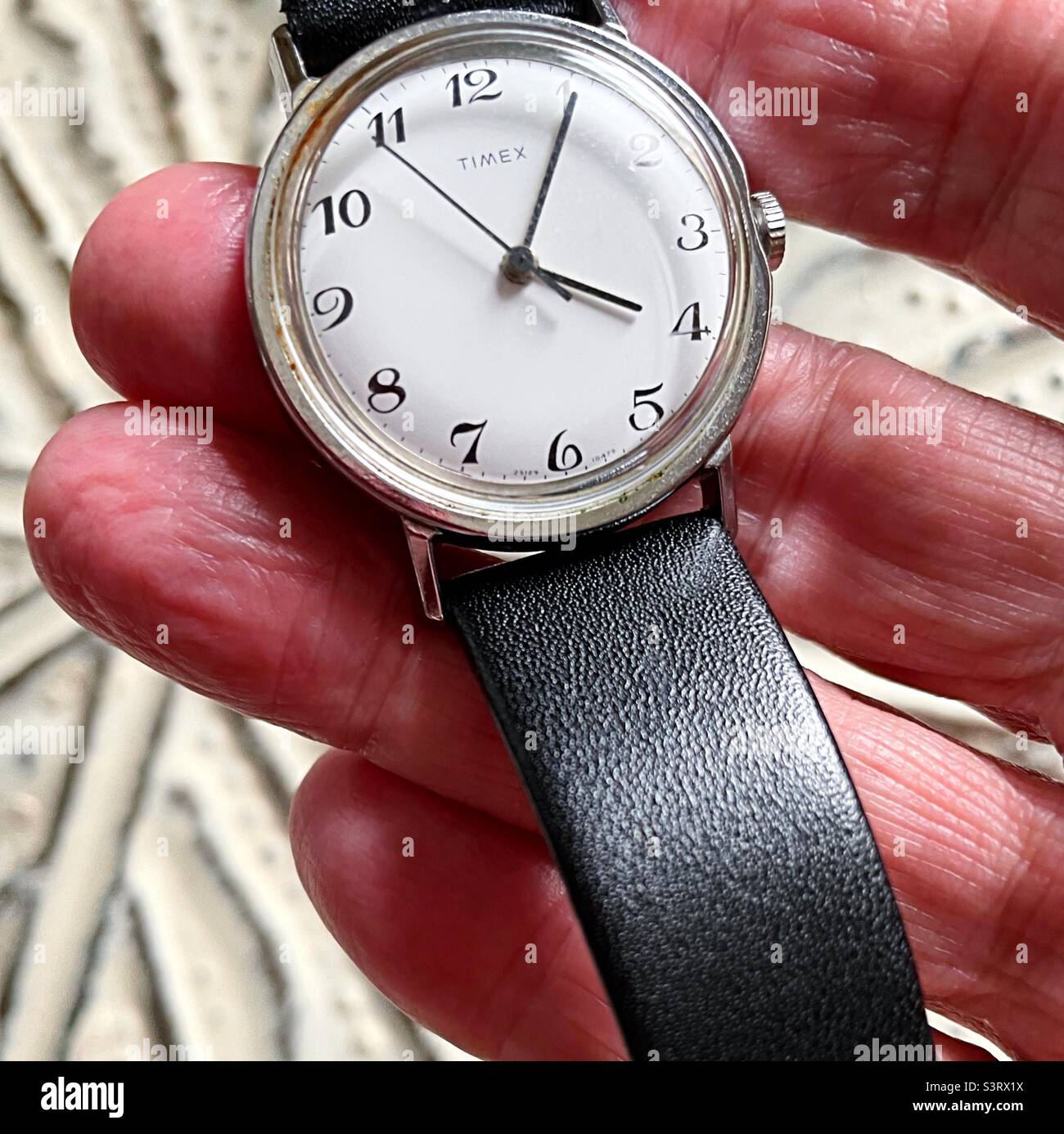Uomo in possesso di un orologio analogico Timex d'epoca, USA - Immagine stock catturata con smartphone
