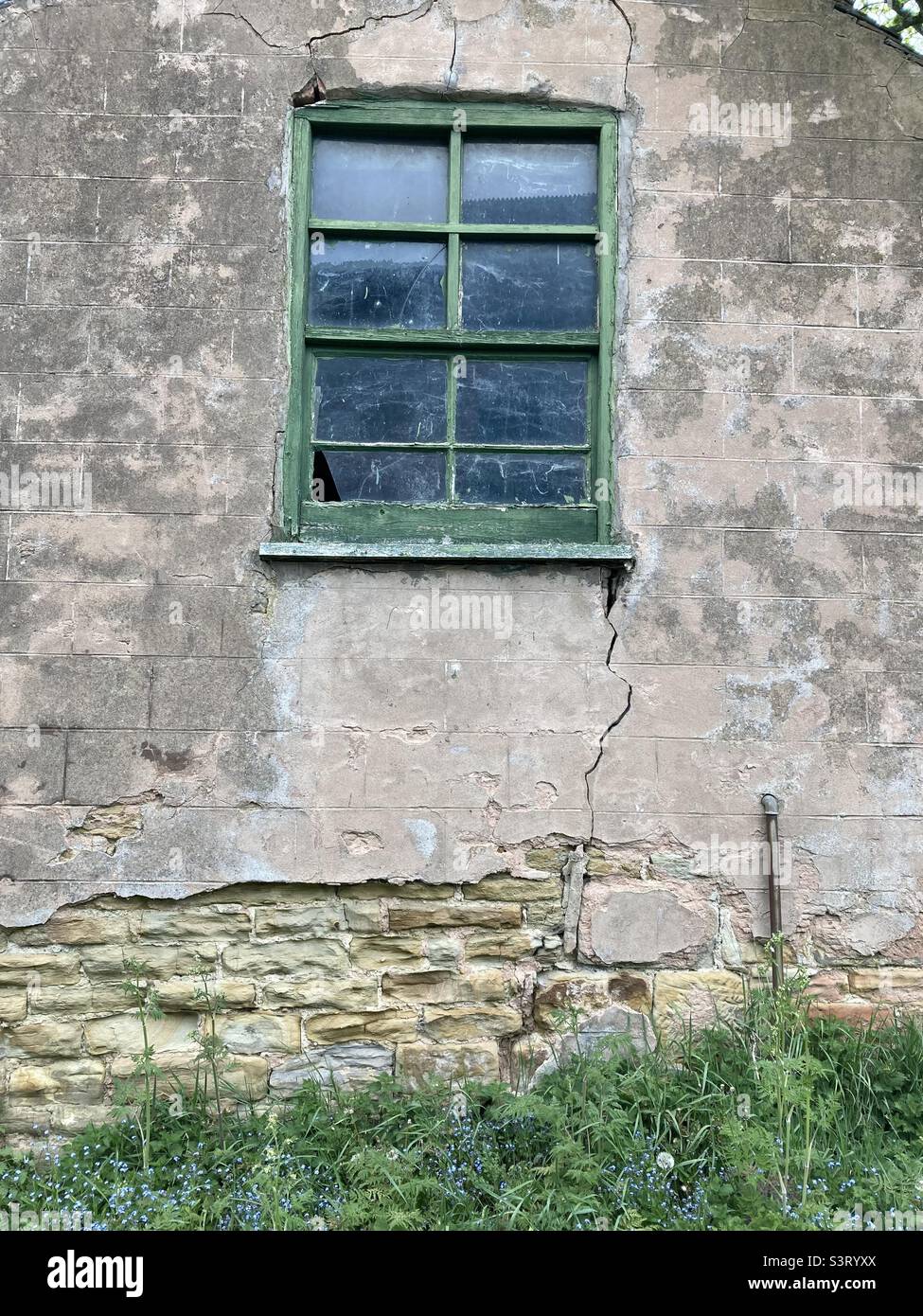 Finestra sul lato di un fienile fattoria di run-down, con crepe e soffiato rendering Foto Stock