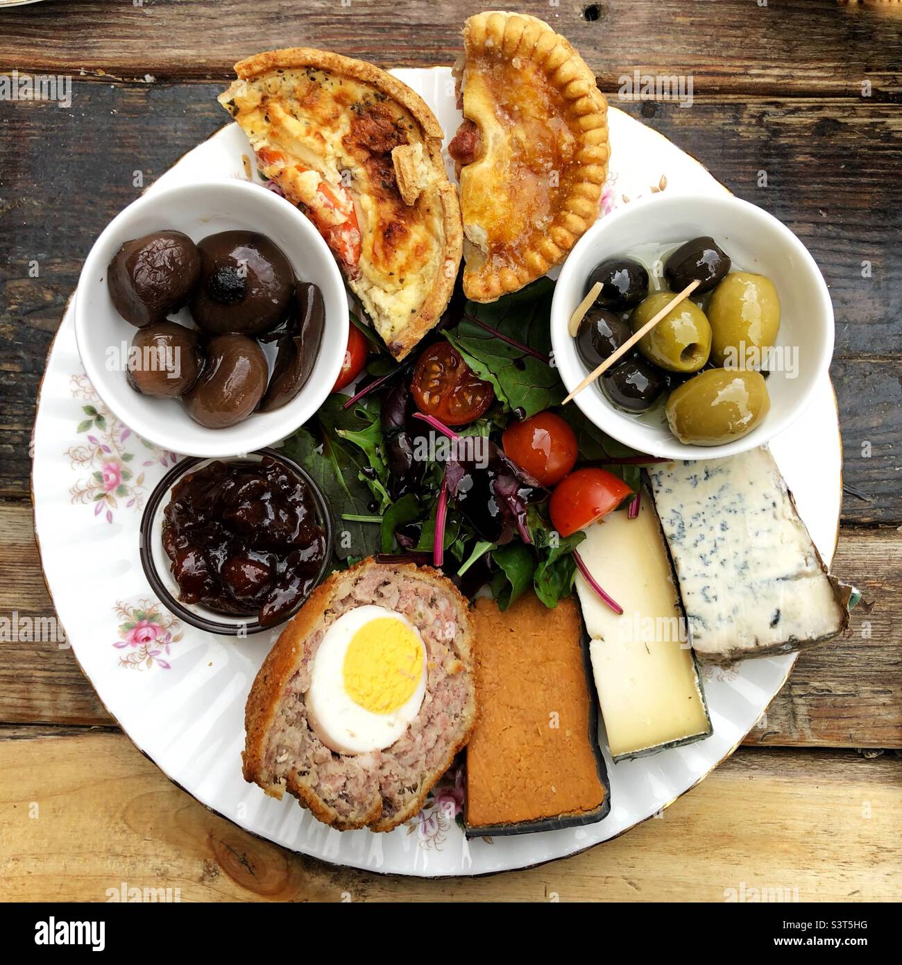 Cibo piatto di un piatto o piatto di Plowman’s lunch con quiche di formaggio d’uovo scotch e sottaceti Foto Stock