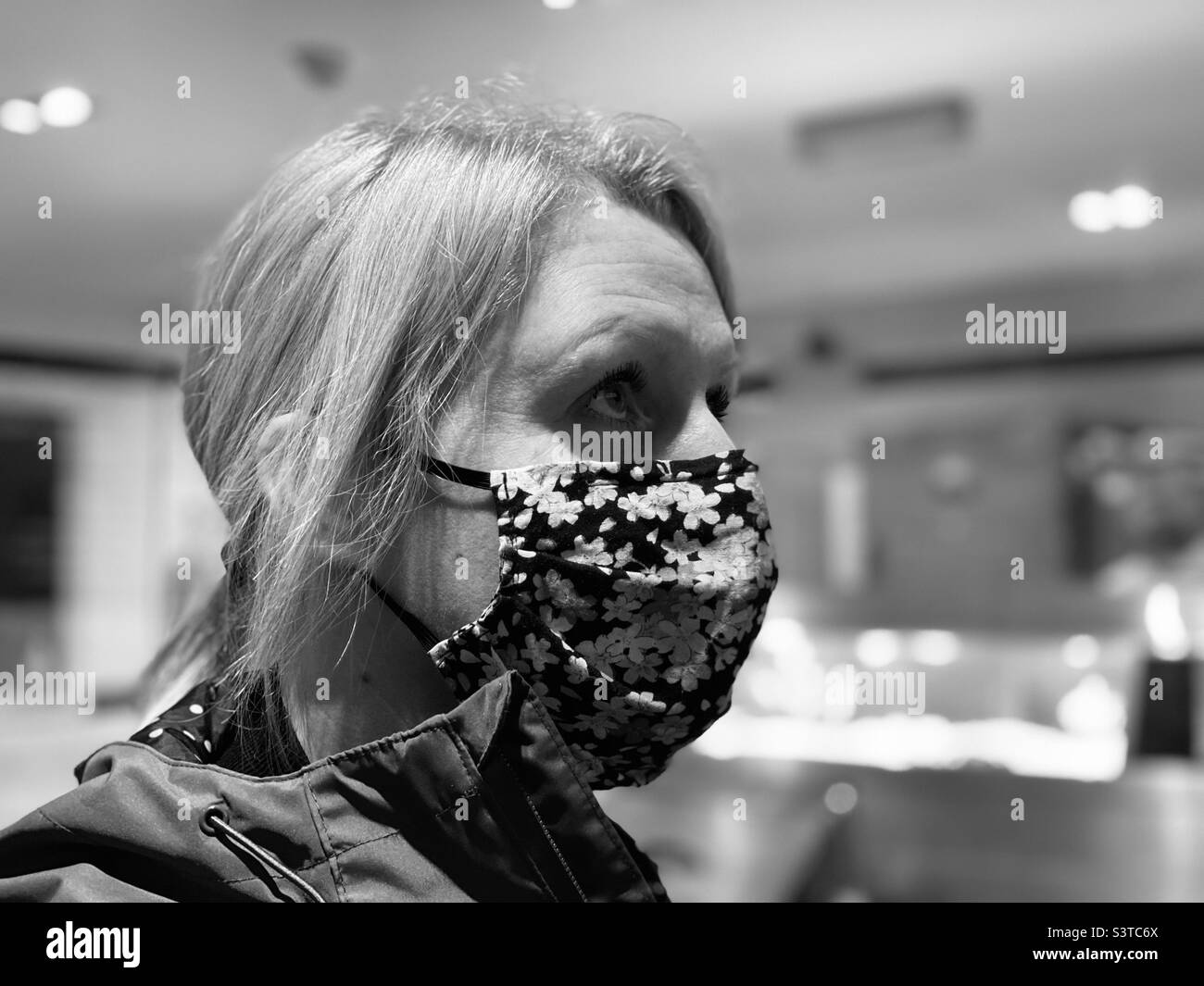 Donna che indossa una copertura per il viso Foto Stock