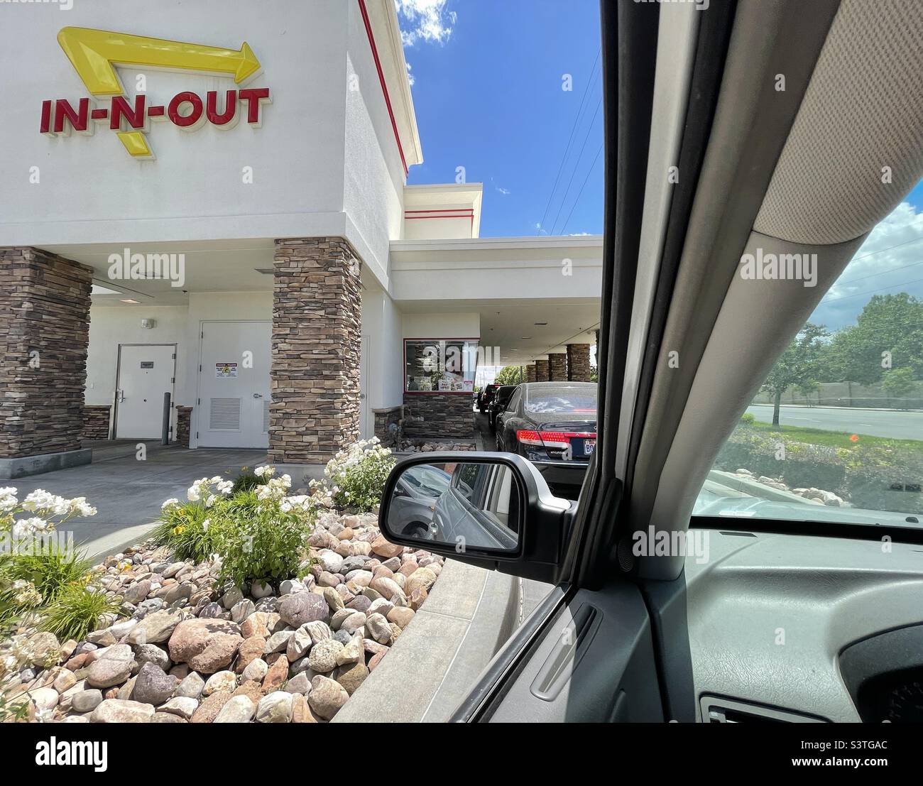 Una vista dall'interno di un'auto in attesa al drive-thru in un ristorante in-n-out Burger fast food in Utah, USA. - Immagine stock catturata con smartphone
