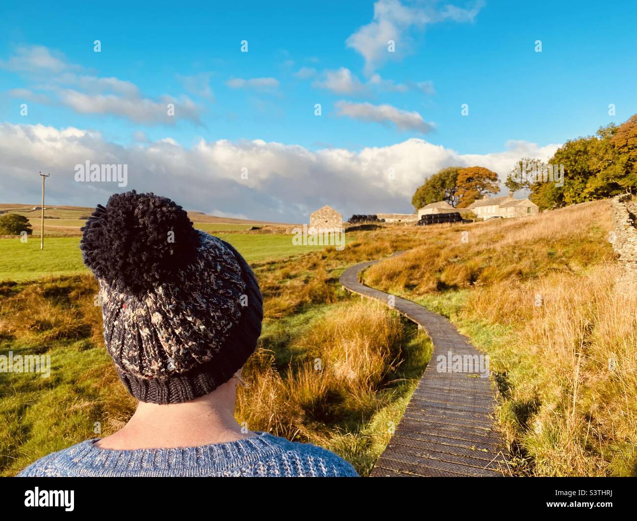 Donna che indossa un cappello a maglia che cammina su una passerella Foto Stock