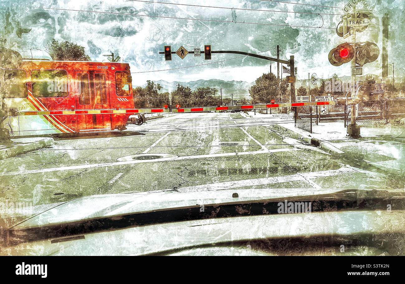 L'auto si è fermata presso un incrocio della Utah Transit Authority TRAX (treno passeggeri) nello Utah, USA. Aggiunta digitale di effetti grunge e invecchiamento. Foto Stock
