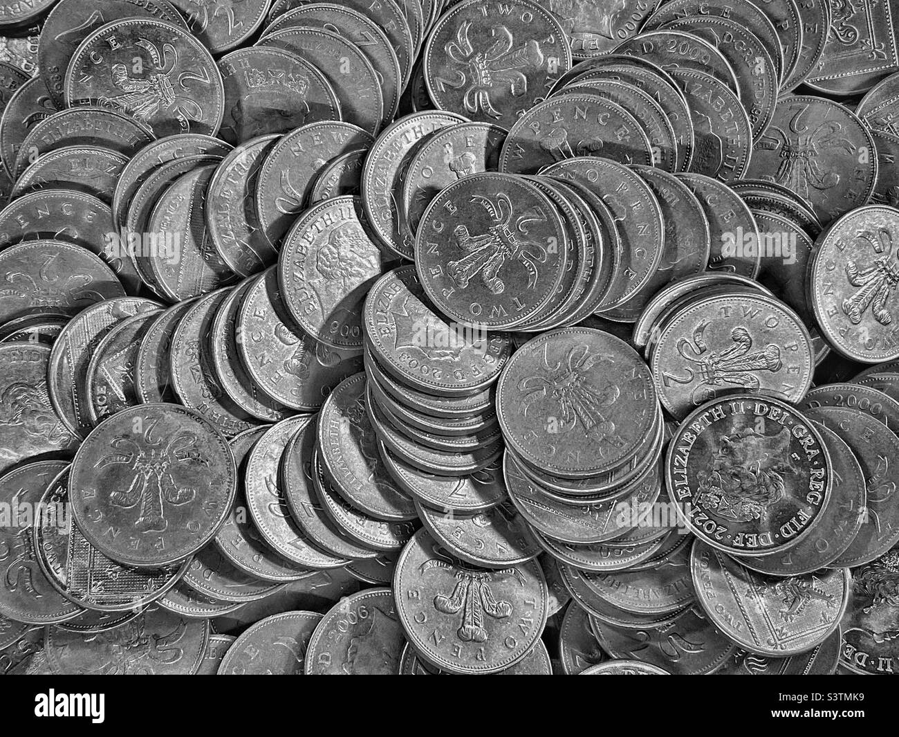 Una grande collezione di monete Bank of England da 2 pence. La valuta è sterline. Questa è una scena familiare in arcate di divertimento dove slot machine sono giocate. Foto ©️ COLIN HOSKINS. - Immagine stock catturata con smartphone