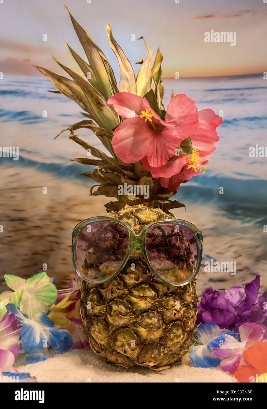 Ananas in occhiali da sole sullo sfondo di una spiaggia tropicale - Immagine stock catturata con smartphone