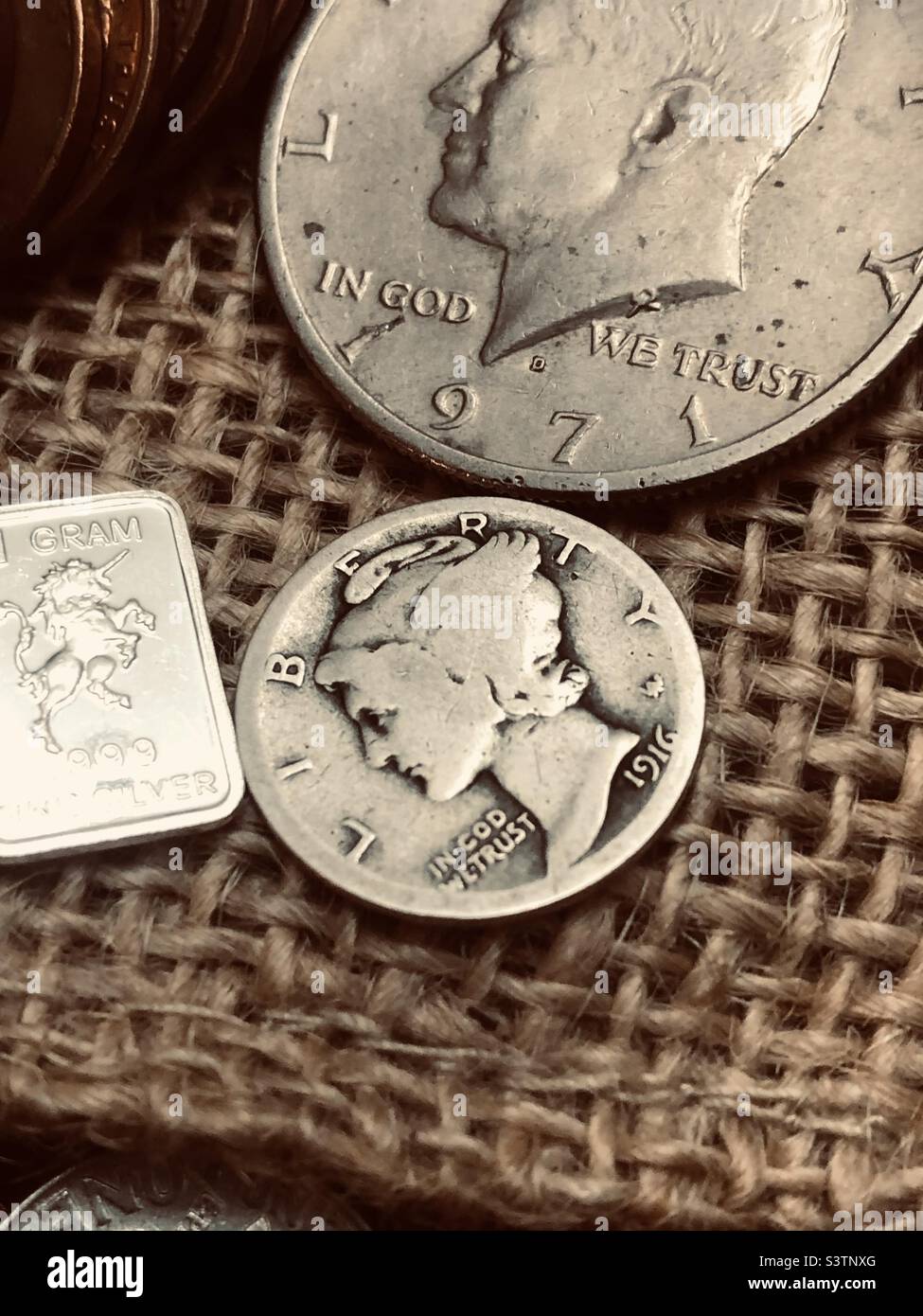Mercurio dime tra altre monete e metalli preziosi. Foto Stock