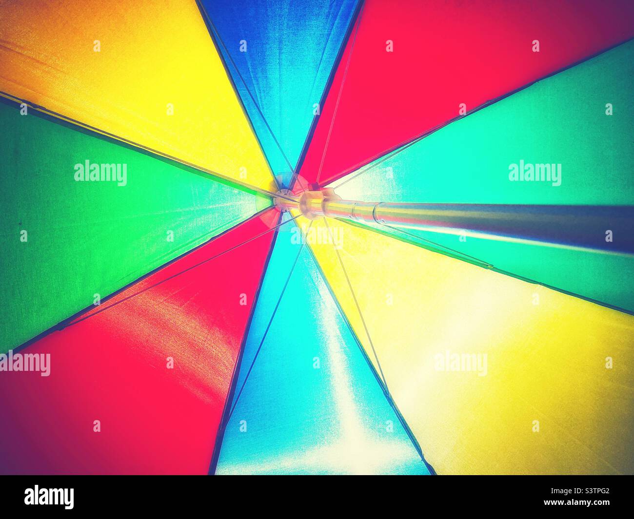 Una vivace fotografia di un ombrellone colorato. Colori primari, sfondo estivo Foto Stock
