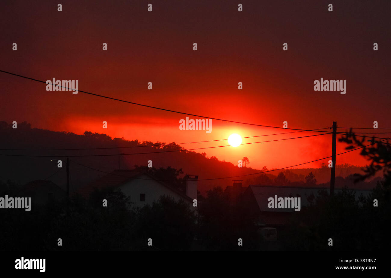 Tramonto rosso scuro e profondo causato dal fumo degli incendi nel Portogallo centrale, luglio 2022 - Immagine stock catturata con smartphone
