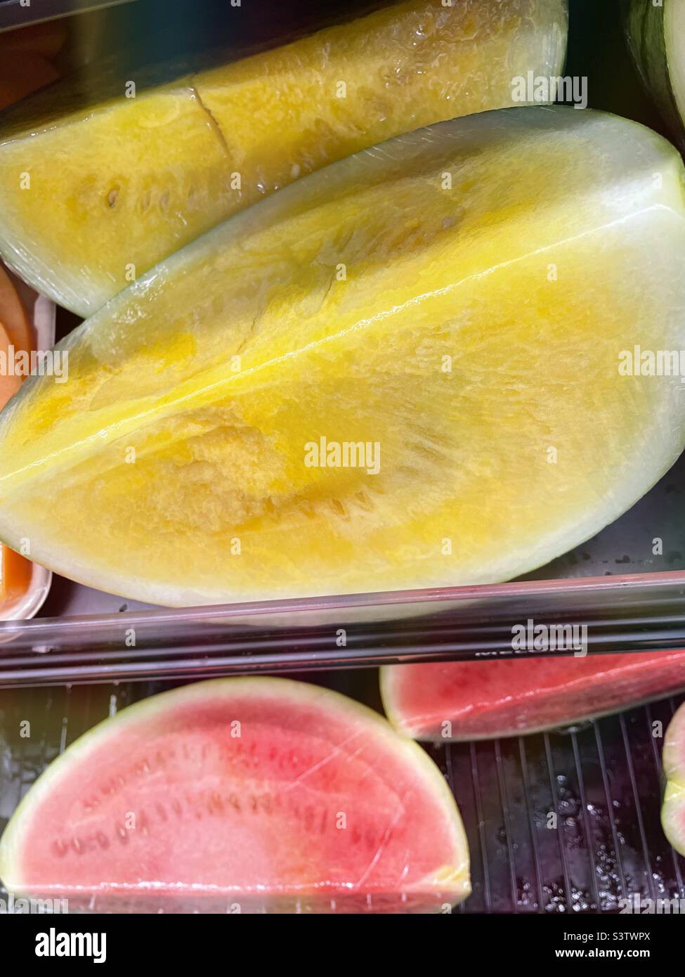 I cocomeri gialli e rossi in vendita in un negozio di alimentari producono navata,2022,USA - Immagine stock catturata con smartphone