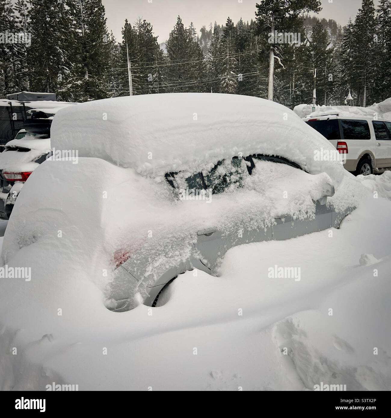 Auto coperta in più di un piede di neve nel parcheggio, Mammoth Mountain, California Foto Stock