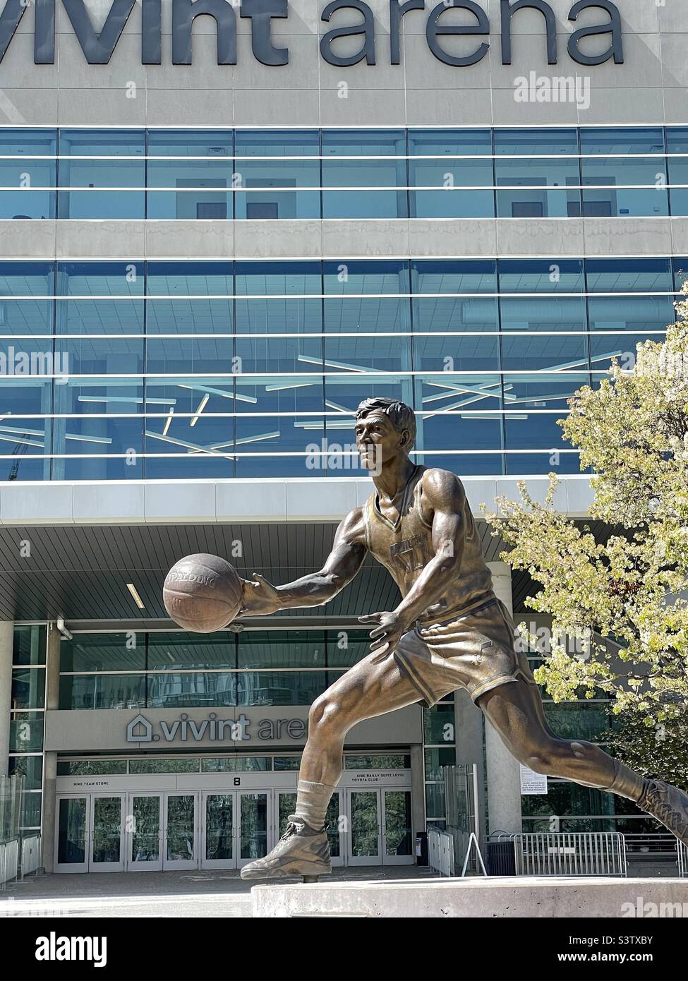 La parte anteriore della Vivint Arena di SLC, Utah, USA, sede della squadra NBA, lo Utah Jazz. Qui è mostrata una delle due statue di bronzo di famosi ex giocatori erette di fronte: John Stockton. - Immagine stock catturata con smartphone