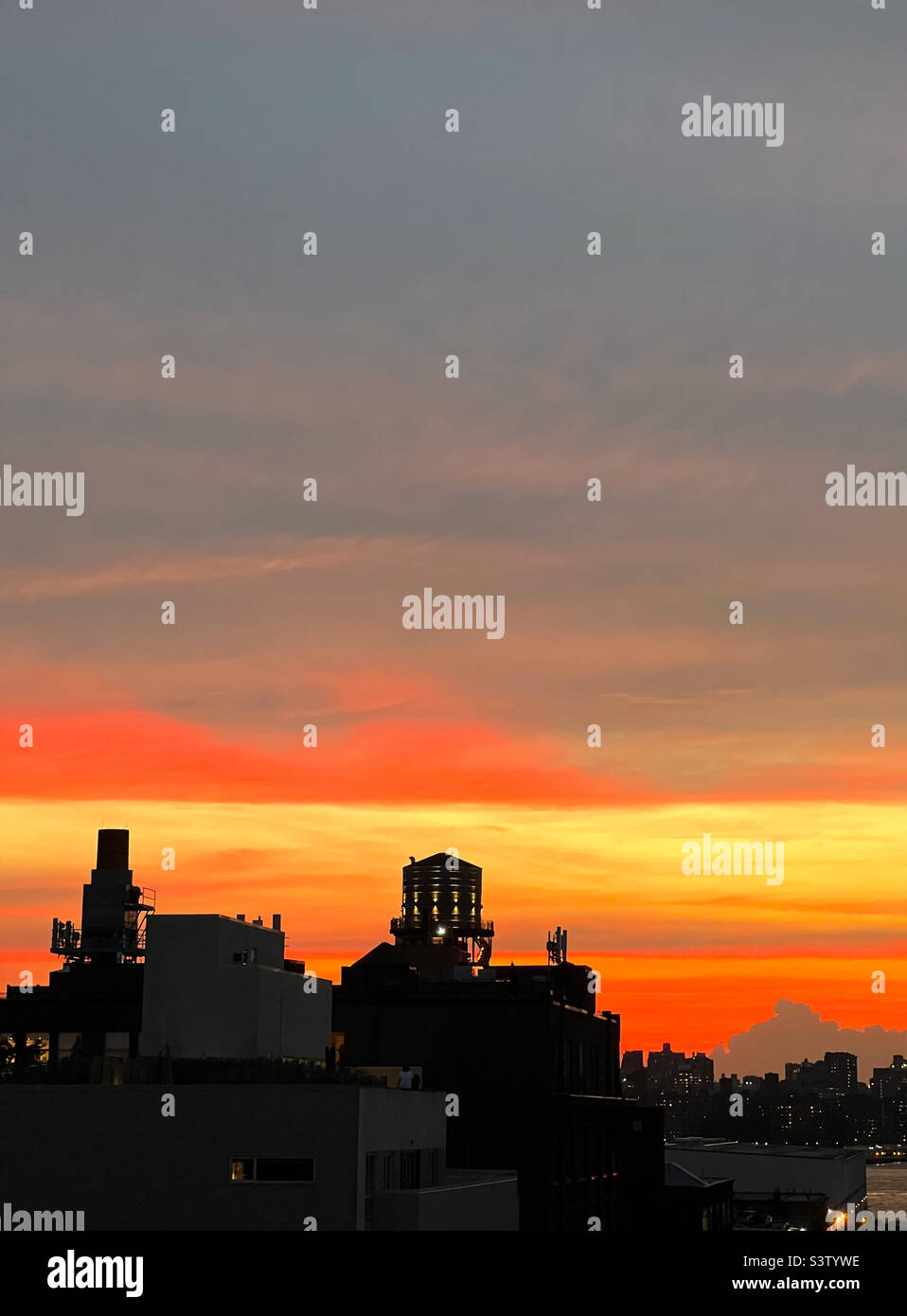 Il tramonto, come osservato da Brooklyn, New York, durante “Manhattanhenge” di martedì 12 luglio 2022. - Immagine stock catturata con smartphone