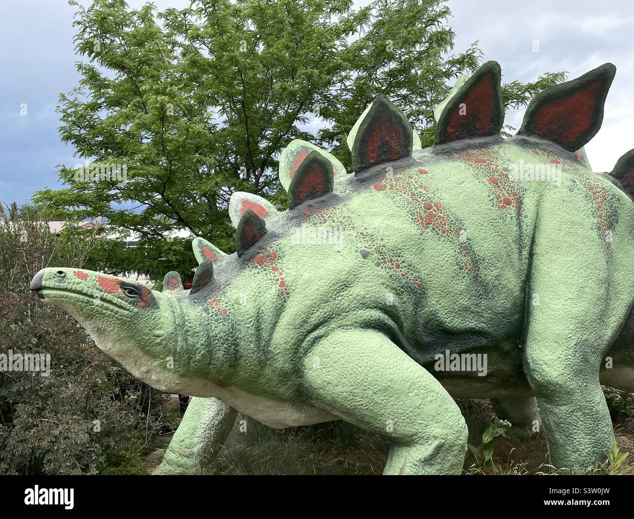 Il cortile all'aperto del Dinosaur Museum di Vernal, Utah, USA, ospita numerose statue di dinosauri disposte in tutto il parco per il piacere degli ospiti, soprattutto dei più piccoli. - Immagine stock catturata con smartphone