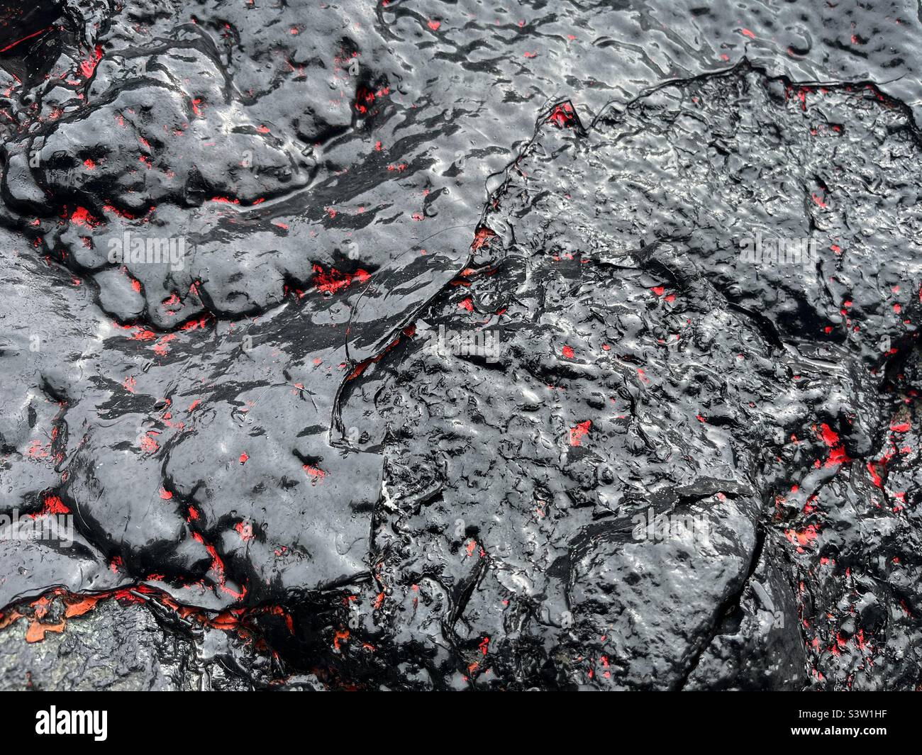 Vernice nera e rossa lucida su roccia - Immagine stock catturata con smartphone