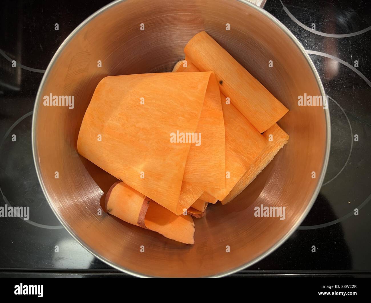 Recipiente in metallo contenente fogli di patate dolci, tagliato per sostituire la pasta in una ricetta senza frumento Foto Stock