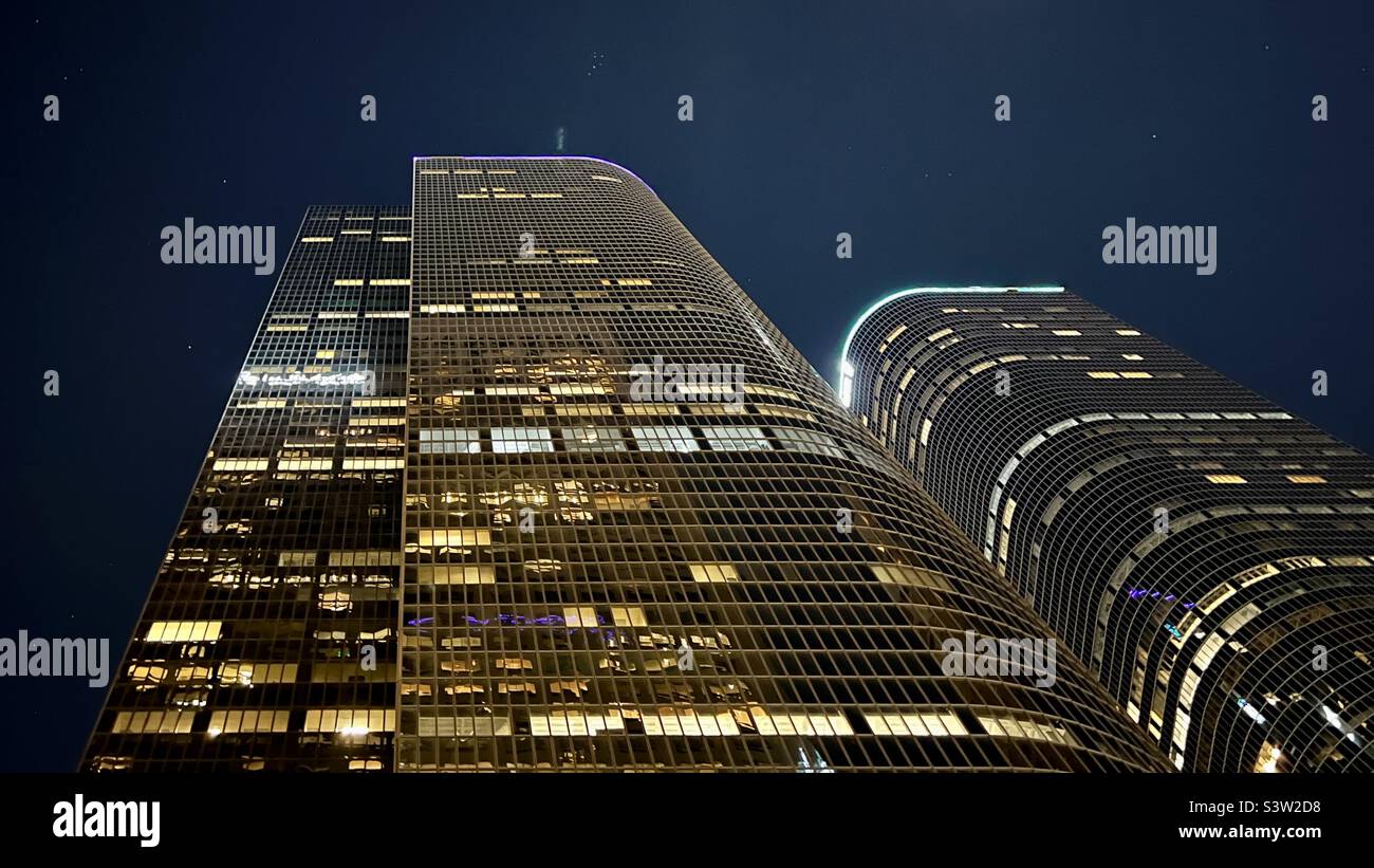 LOS ANGELES, CA, FEBBRAIO 2022: Guardando verso l'alto i grattacieli gemelli di uno e due California Plaza di notte, gli uffici illuminati di notte nel quartiere finanziario del centro - Immagine stock catturata con smartphone