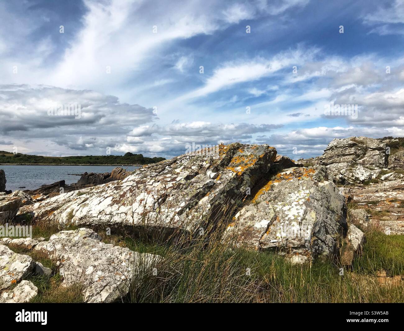 Rocce ricoperte di licheni sulla costa di Carrick sulle rive della baia di Wigtown nel sud-ovest della Scozia - Immagine stock catturata con smartphone