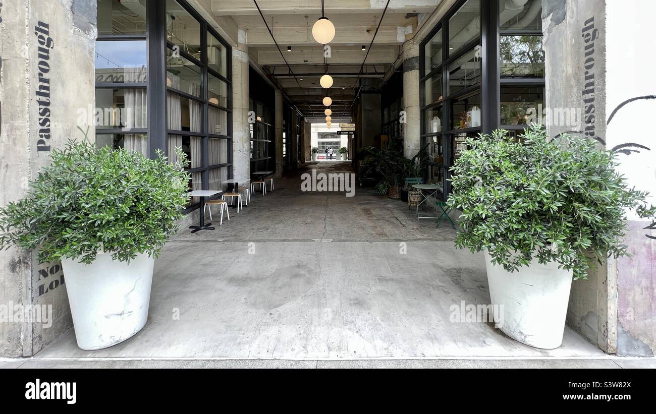 LOS ANGELES, CA, Apr 2022: Ampio passaggio visivo attraverso l'edificio a The Row, ridefinito edifici industriali ora utilizzati come creativa, leggera produzione e area di vendita al dettaglio nel quartiere di produzione, nel centro città - Immagine stock catturata con smartphone