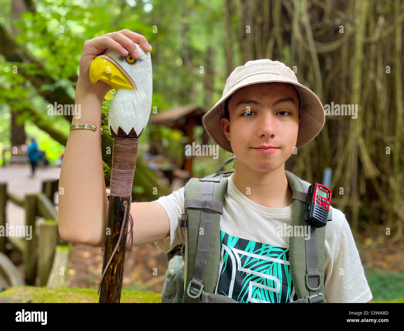 Ritratto di un adolescente con un bastone da passeggio a testa di aquila mentre camminate a Muir Woods, California. Foto Stock