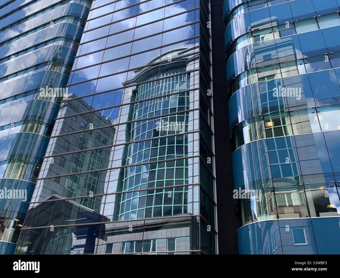 Riflessione nell'edificio st botolph aldgate a Londra est il giorno d'estate - Immagine stock catturata con smartphone
