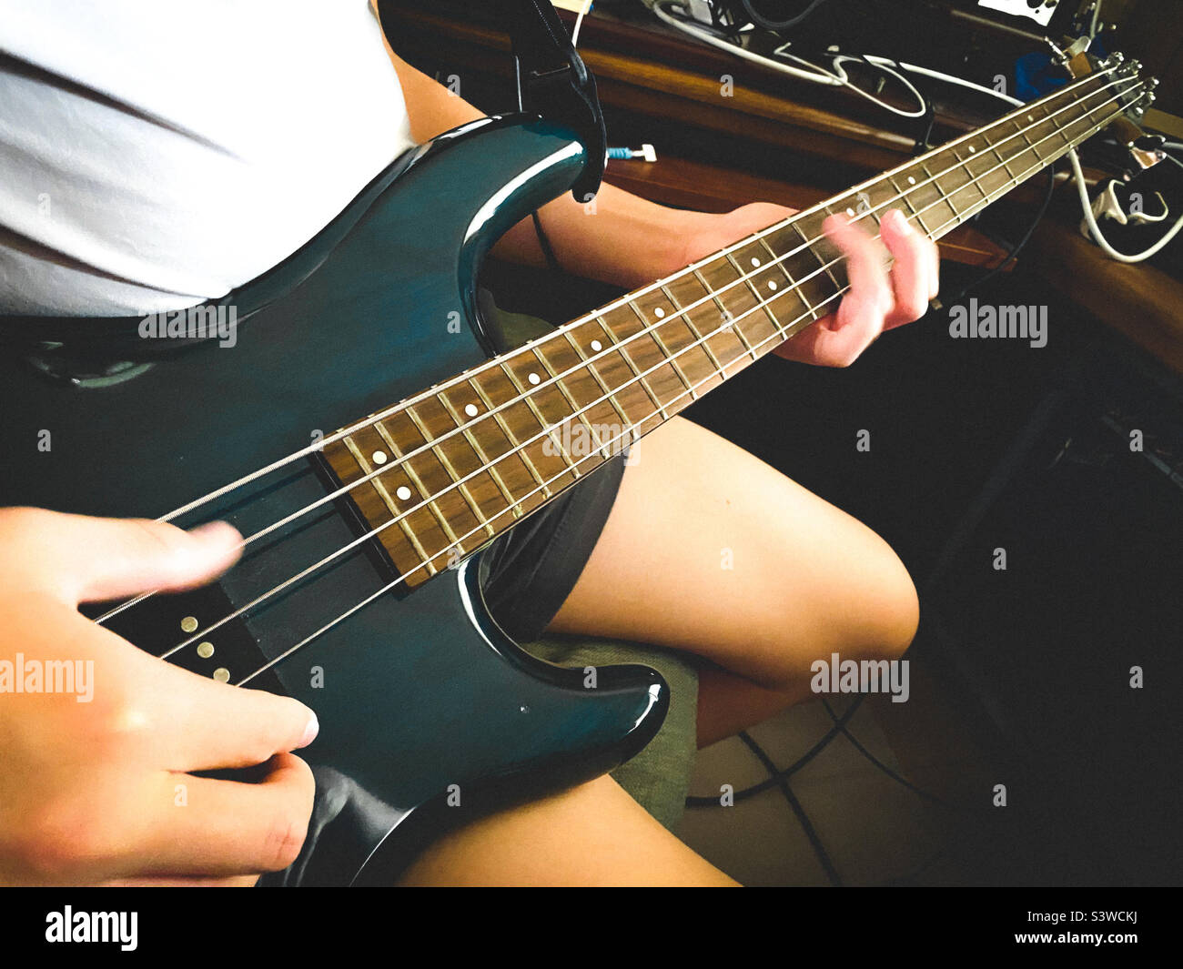 Un ragazzo che suona una chitarra elettrica basso Foto Stock