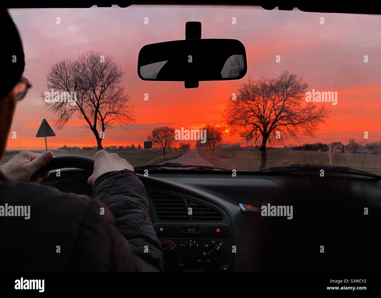 Guida di un'auto al tramonto Foto Stock