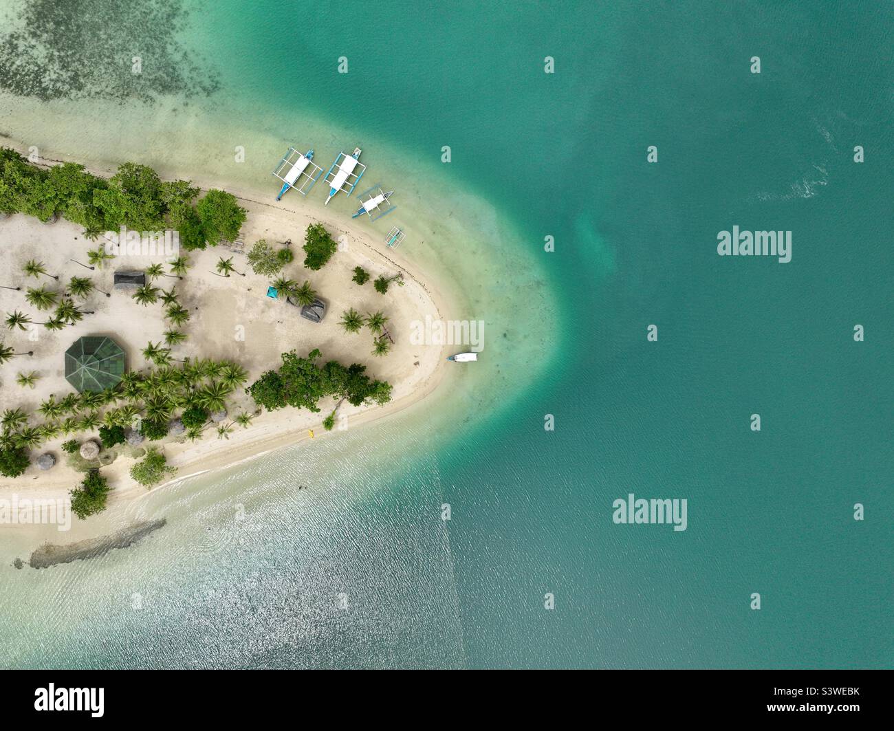 Vivi la vita in un'isola incontaminata con una spiaggia bianca circondata da acqua smeraldo. Scatto aereo di vivere in un'isola isolata. Foto Stock