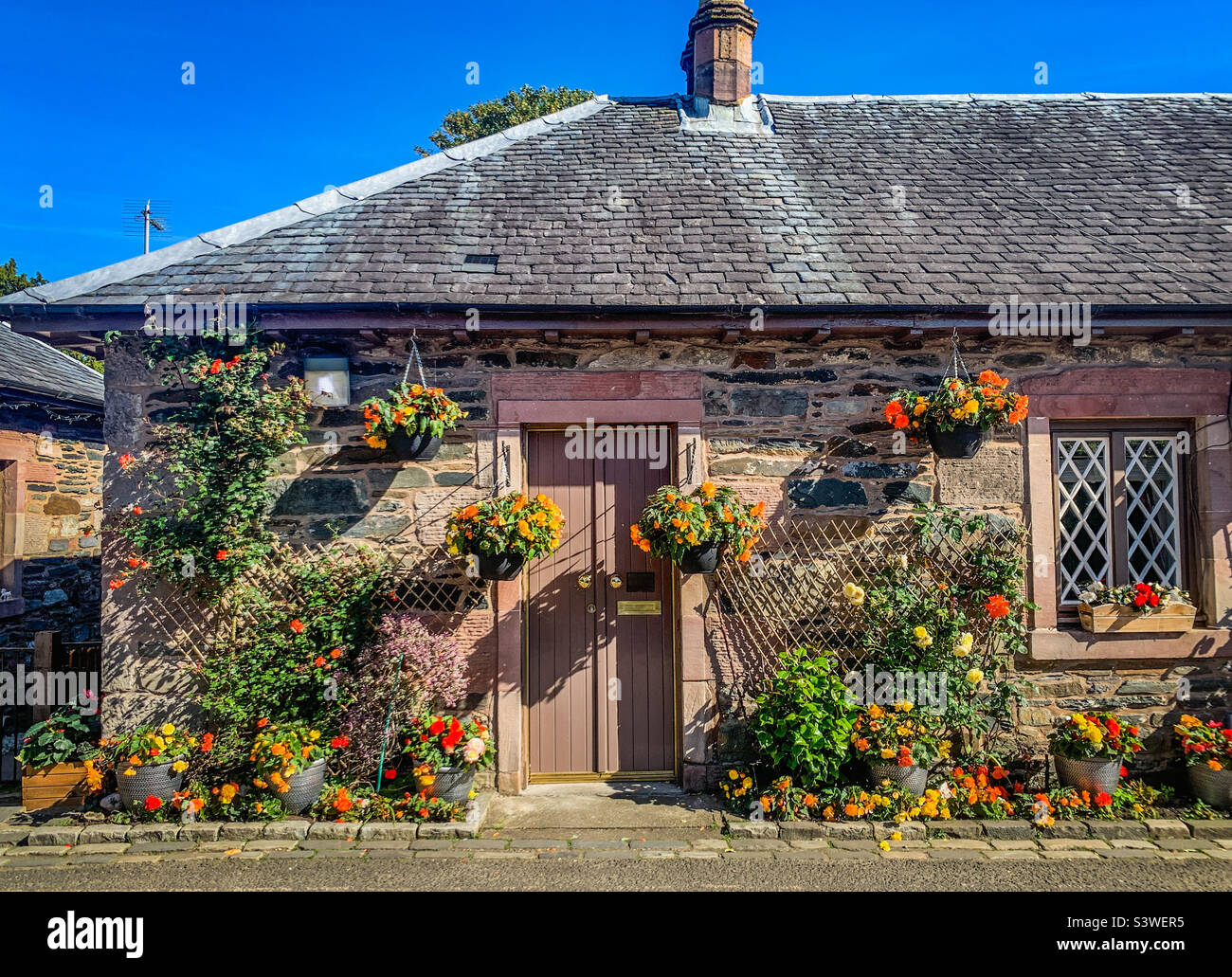 Mostra di fiori in una casa nel villaggio di Luss a Loch Lomond, Scozia Foto Stock