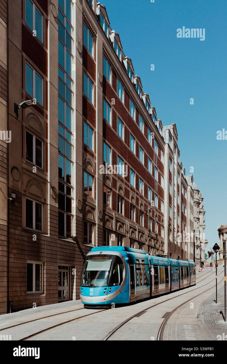 Un tram della metropolitana delle West Midlands su una strada di Birmingham City con architettura storica e antica con spazio copia Foto Stock