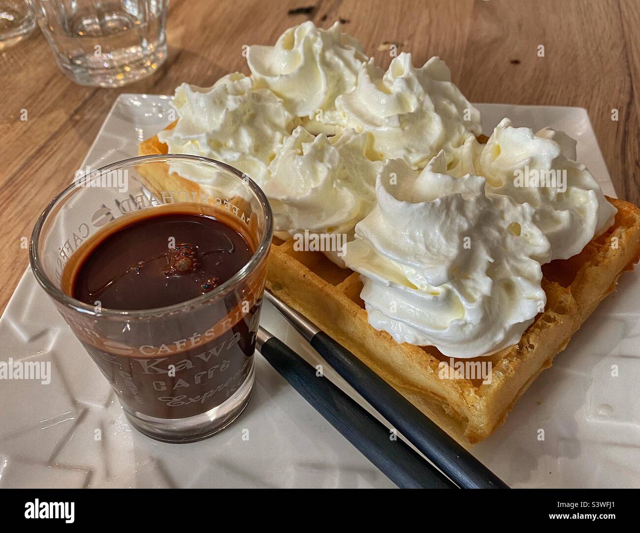 Waffle belgi con panna Chantilly e salsa al cioccolato caldo Foto Stock