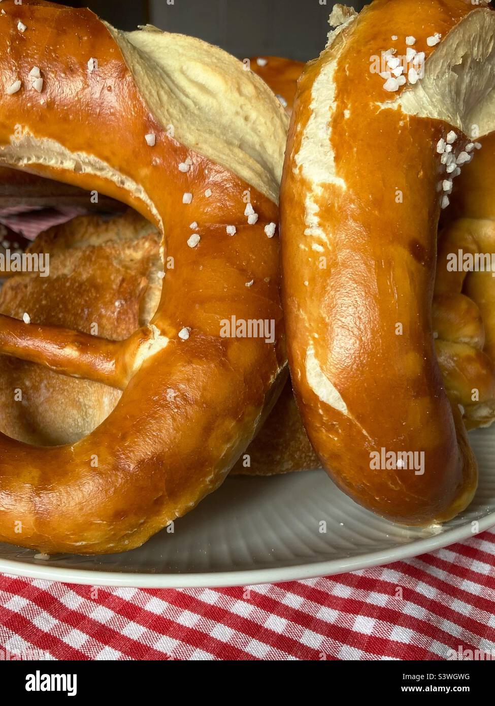 Pretzel su un piatto su un panno da tavolo a scacchi - Immagine stock catturata con smartphone