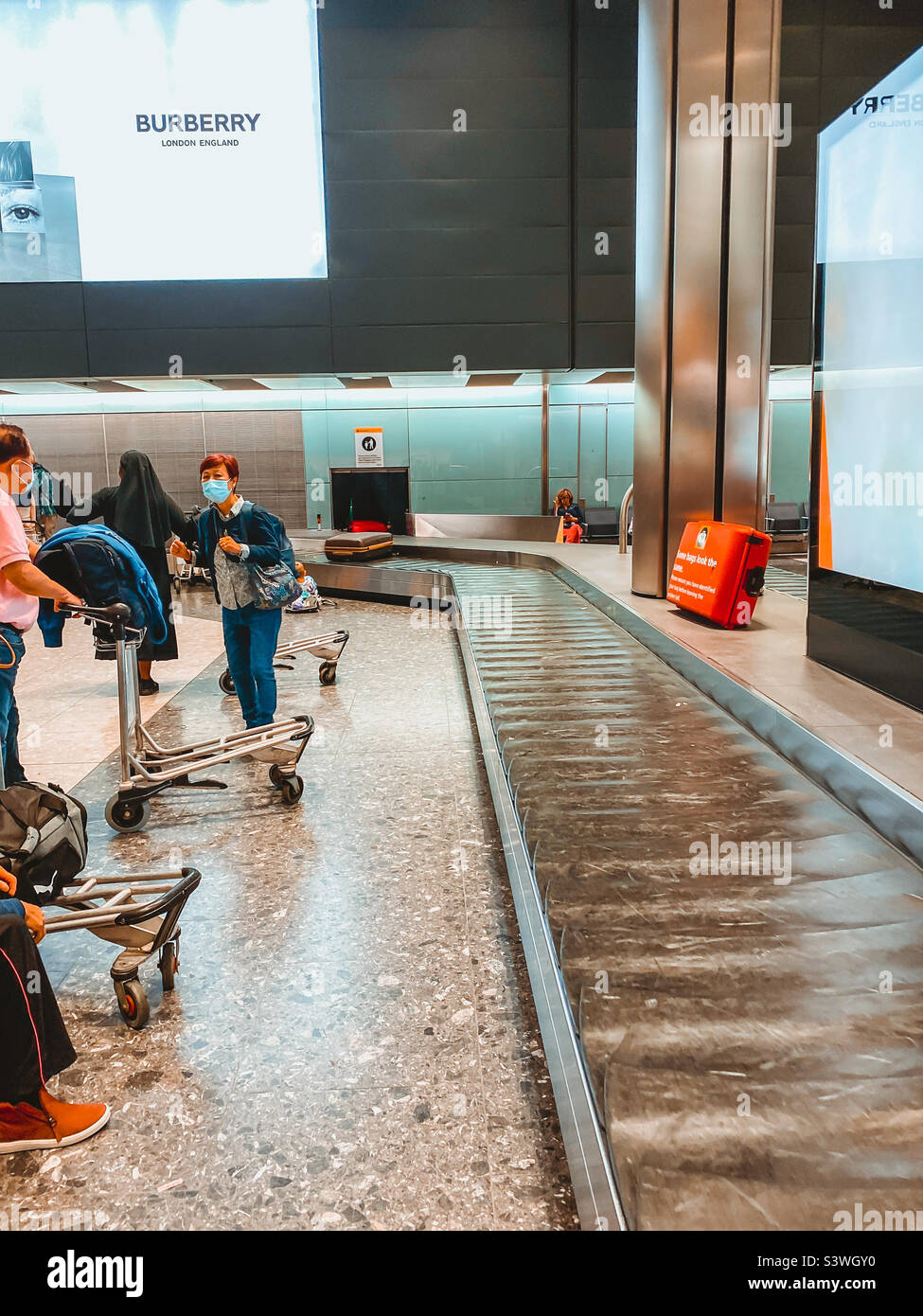Attesa al ritiro bagagli all'aeroporto Heathrow di Londra dopo l'arrivo su un volo a lunga percorrenza. Foto Stock