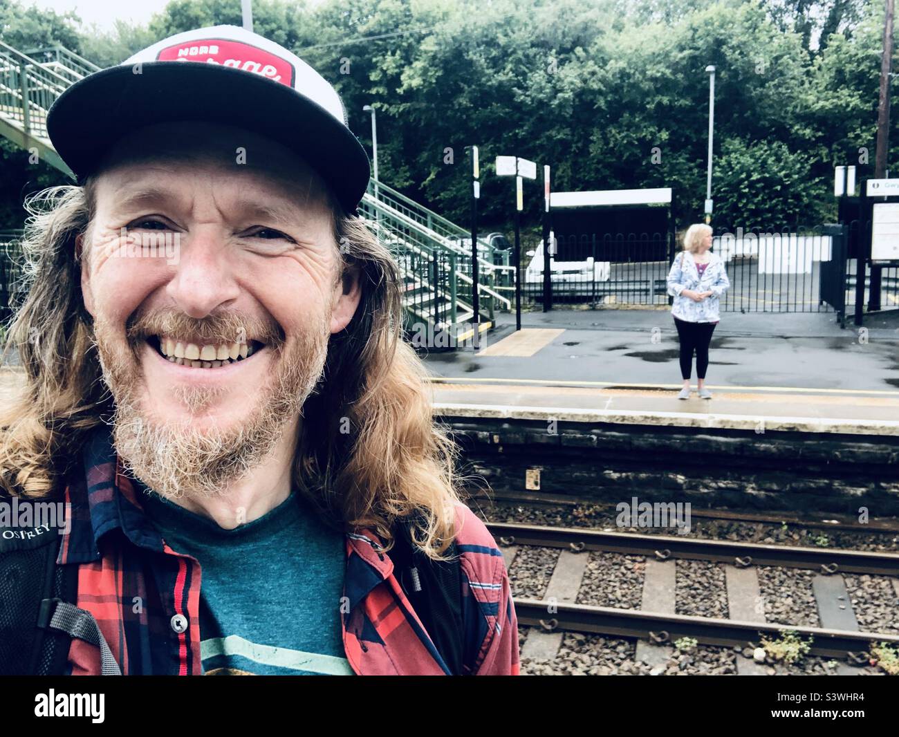 Un uomo e una donna in una piccola piattaforma ferroviaria - Immagine stock catturata con smartphone