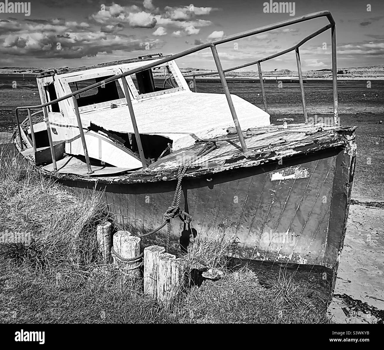 “Ex Gloria” una vecchia barca, legata e abbandonata nel porto dopo anni di utilizzo in quella che sarebbe stata una giornata perfetta sull’acqua (bianco e nero) Foto Stock