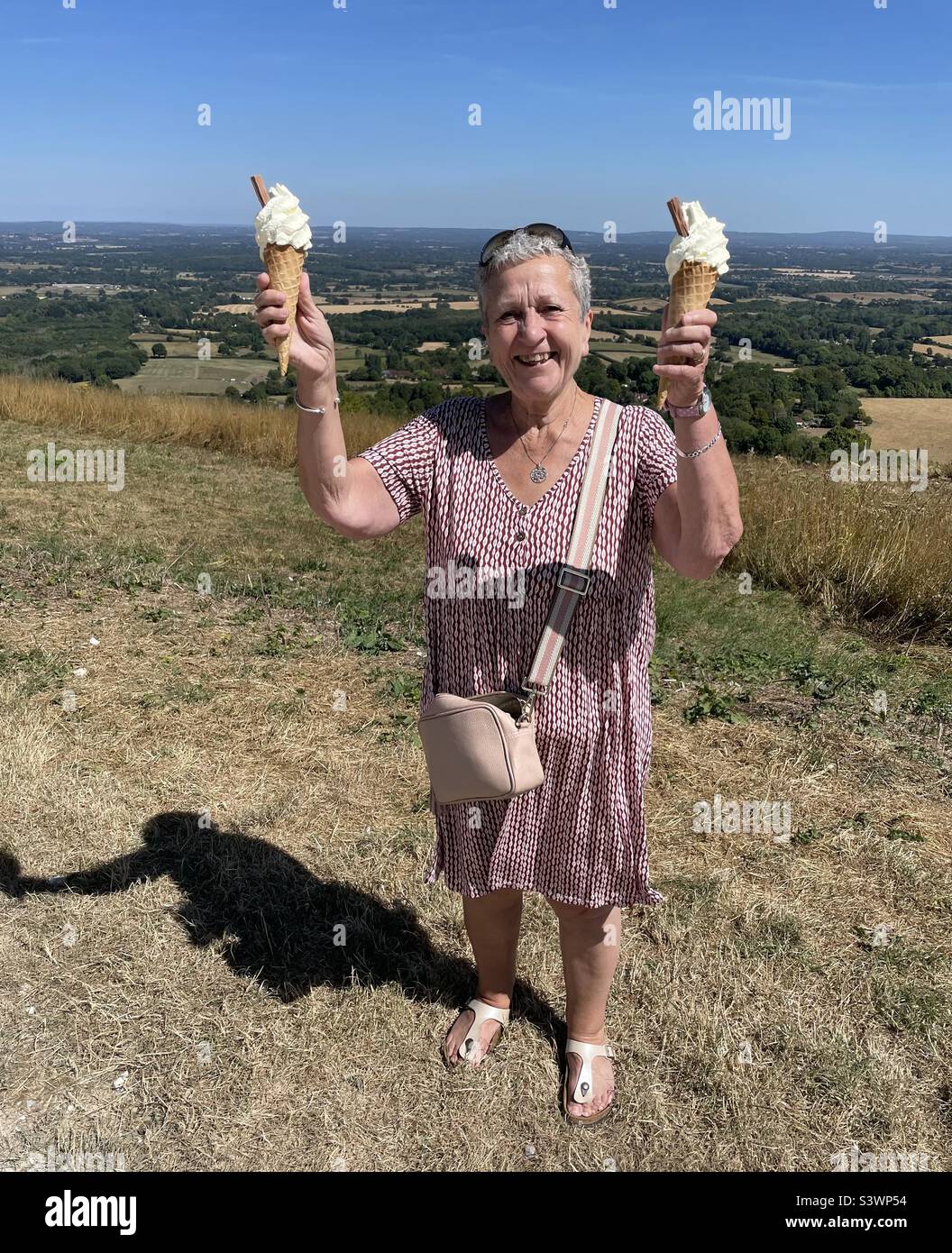 Signora con due gelati da 99 ml sulle South Downs Foto Stock