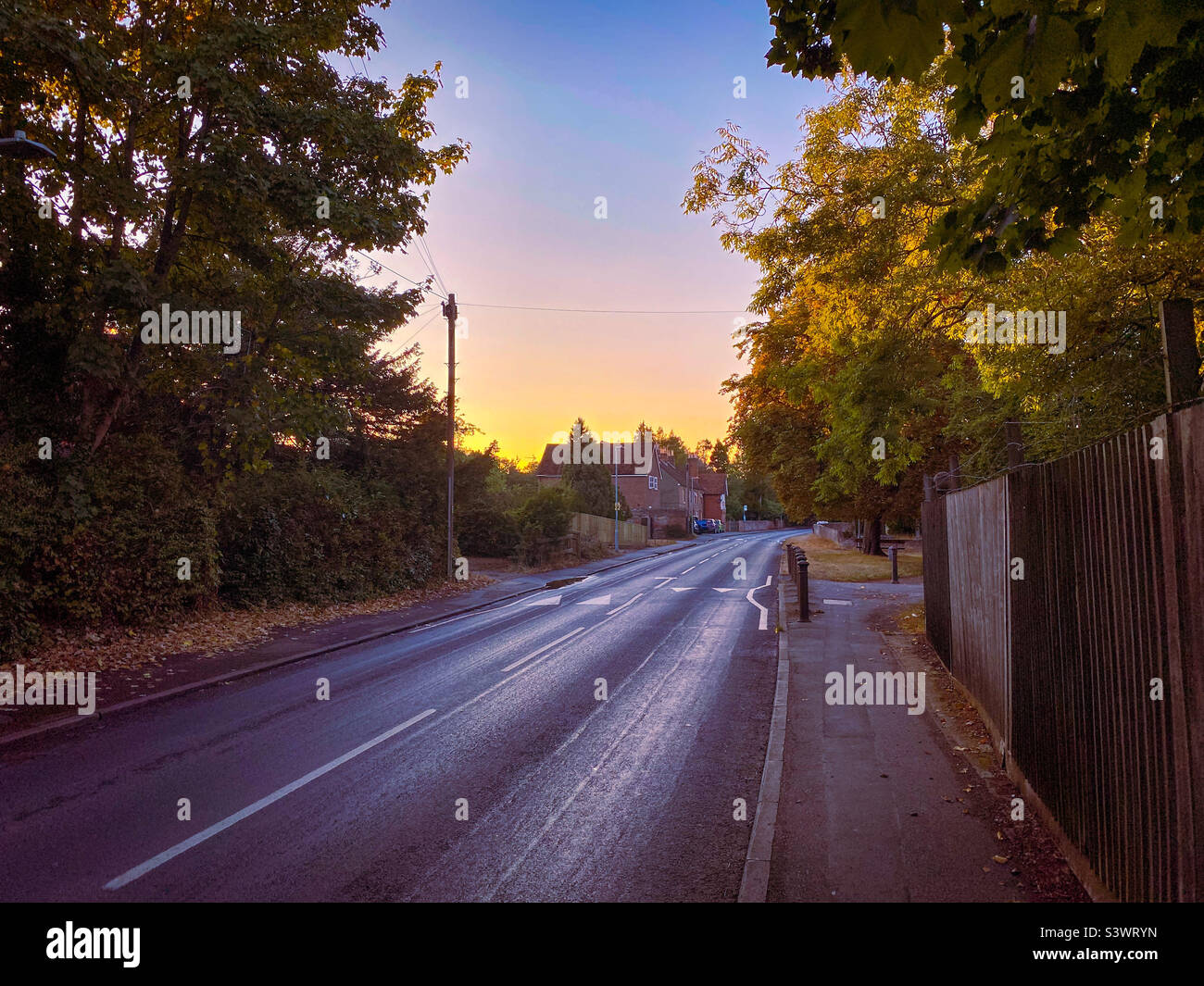 Una vista lungo New Lane Hill a Tilehurst, Reading, Regno Unito, mentre il sole comincia a tramontare. - Immagine stock catturata con smartphone