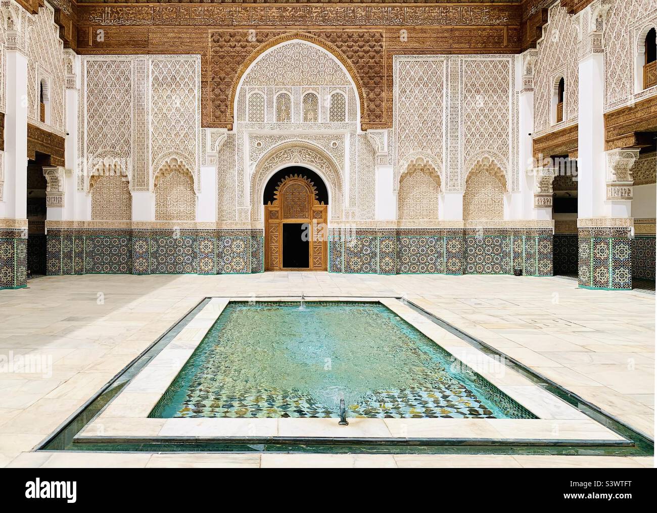 Il cortile principale e la piscina riflettente nella Madrasa ben Youssef, un tempo la più grande scuola islamica del Marocco, Marrakech, Marocco, Nord Africa. Foto Stock