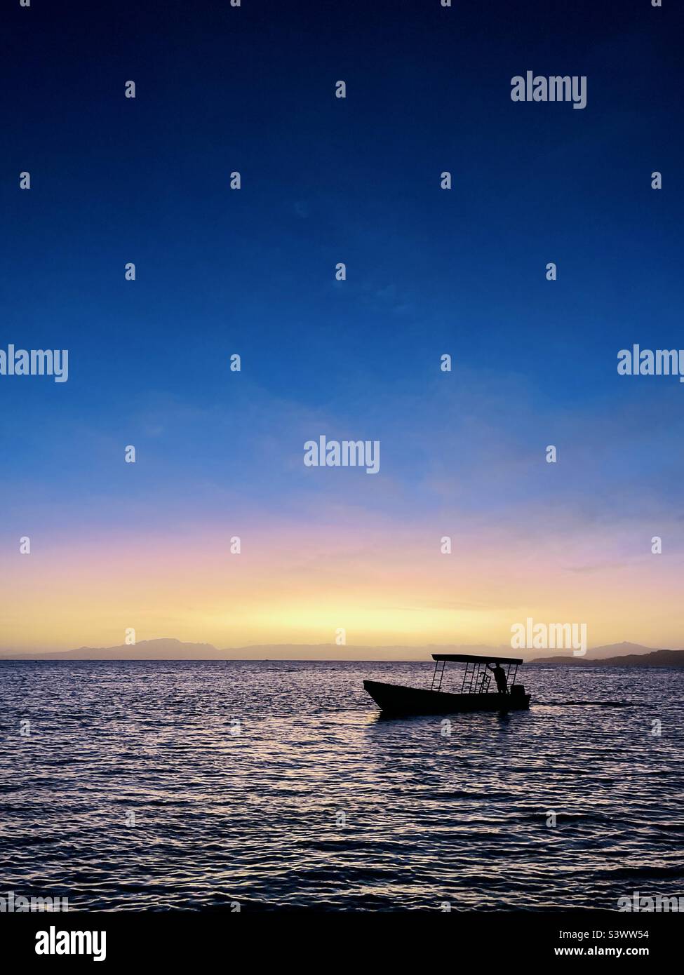 Una barca a motore Panga vicino alla riva al mattino presto. Isola di Tavarua, Figi. Foto Stock