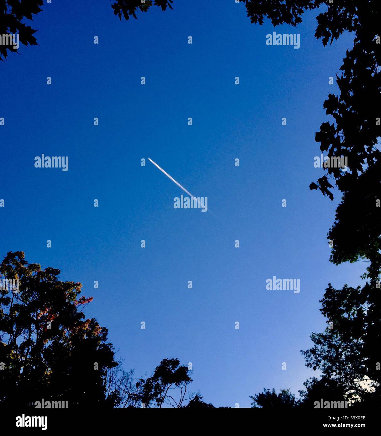 Jet trail in un cielo blu. Su e via. Nel yonder blu. - Immagine stock catturata con smartphone