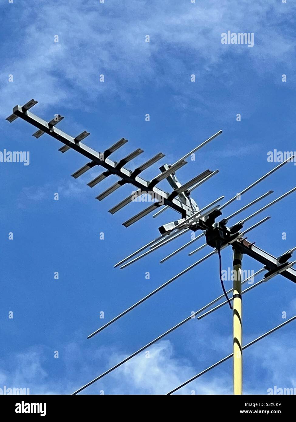 Antenna TV analogica ancora trovata in cima ad un tetto in Utah, Stati Uniti sotto cielo blu. - Immagine stock catturata con smartphone