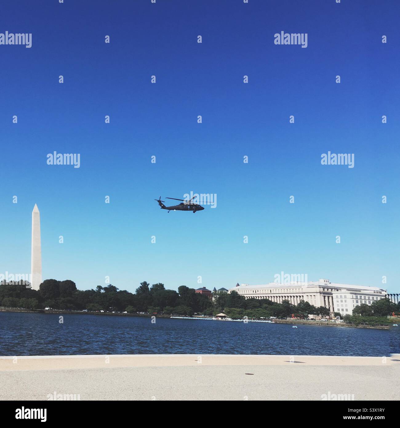 Silhouette in elicottero sorvolando Washington DC con monumento e Museo di Storia Naturale sullo sfondo - Immagine stock catturata con smartphone
