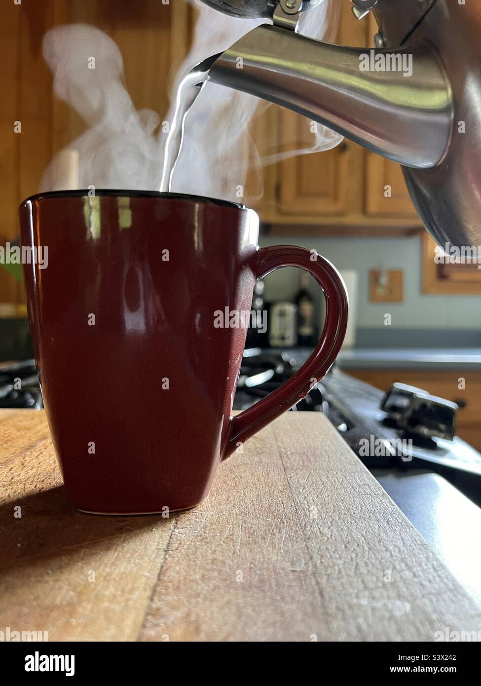 Che ne dici di un caffè? Vapore che sale da una tazza e dal beccuccio del teakettle in mezzo versare. - Immagine stock catturata con smartphone