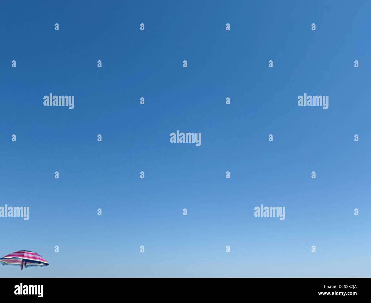 Ombrello colorato contro il cielo blu Foto Stock