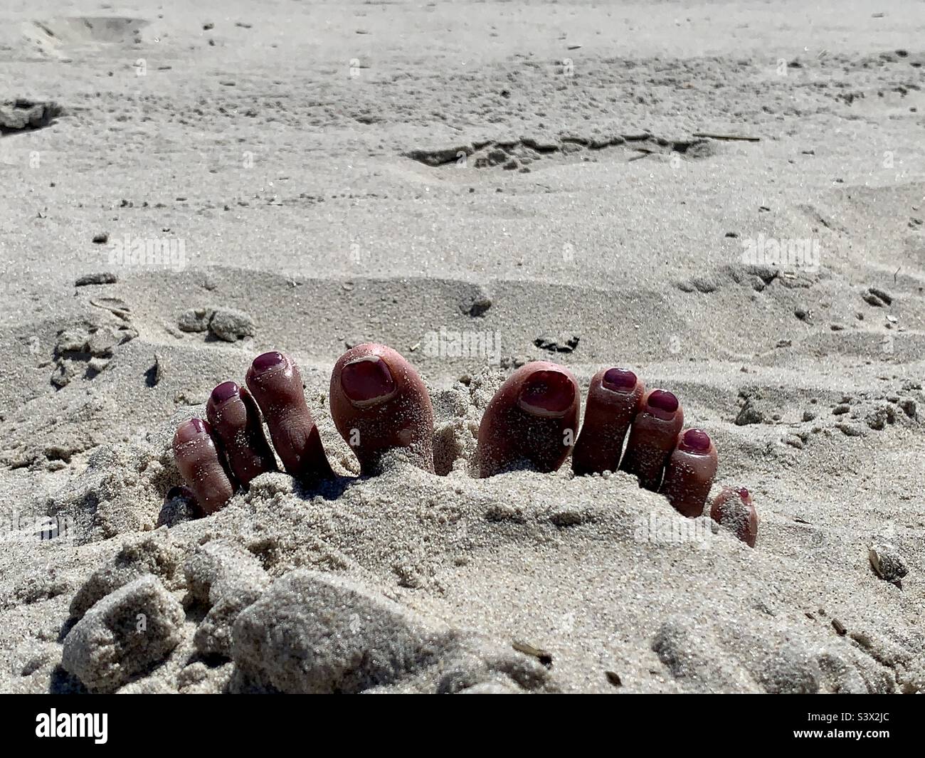 Piedi sepolti sulla sabbia Foto Stock